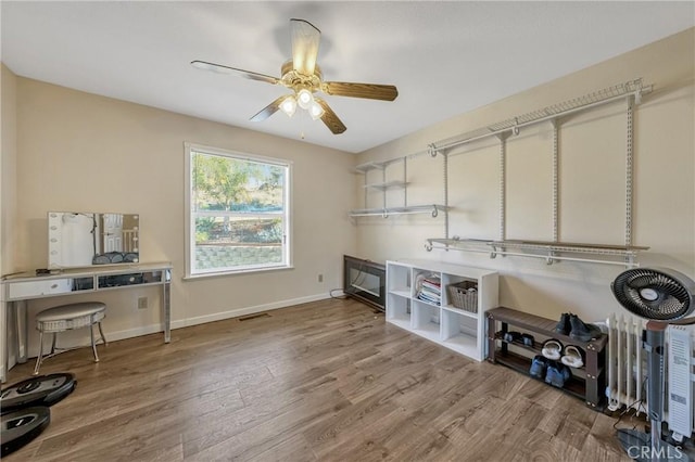 clothes washing area with hardwood / wood-style flooring and ceiling fan