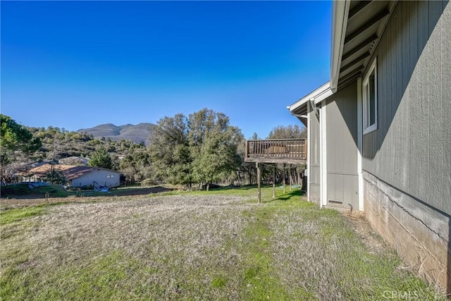 view of yard featuring a deck with mountain view