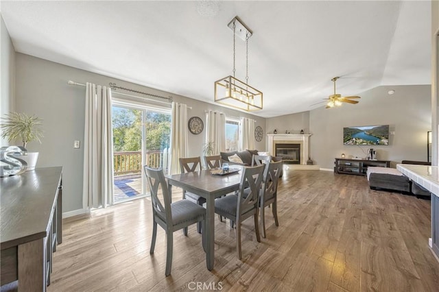 dining space with hardwood / wood-style flooring, vaulted ceiling, and ceiling fan