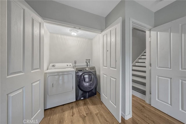 clothes washing area featuring light hardwood / wood-style floors and independent washer and dryer