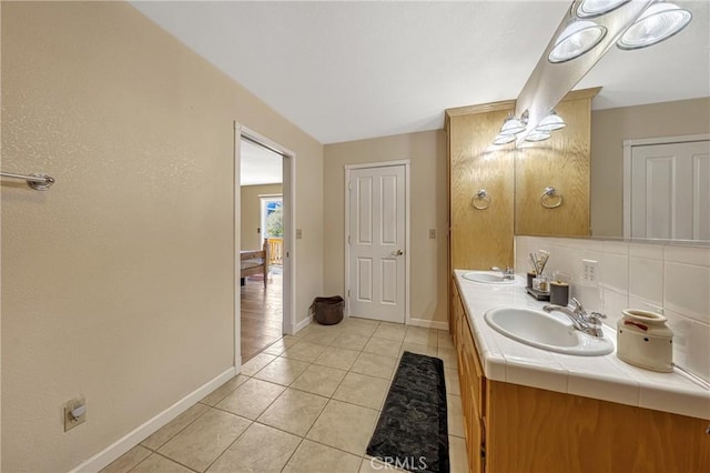 bathroom with tasteful backsplash, vanity, and tile patterned flooring