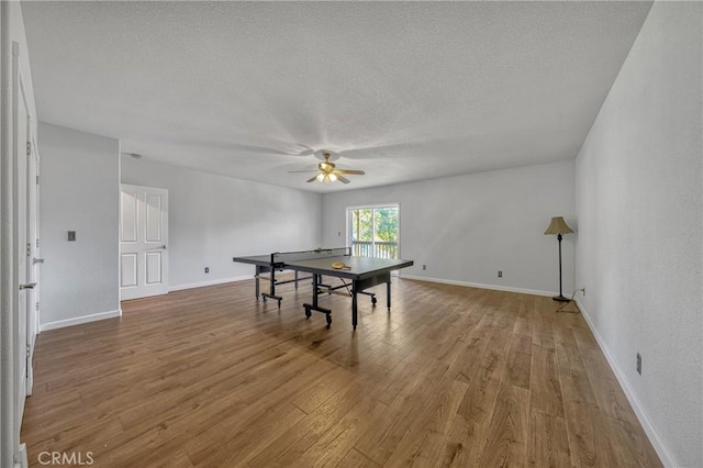 game room featuring hardwood / wood-style floors, a textured ceiling, and ceiling fan