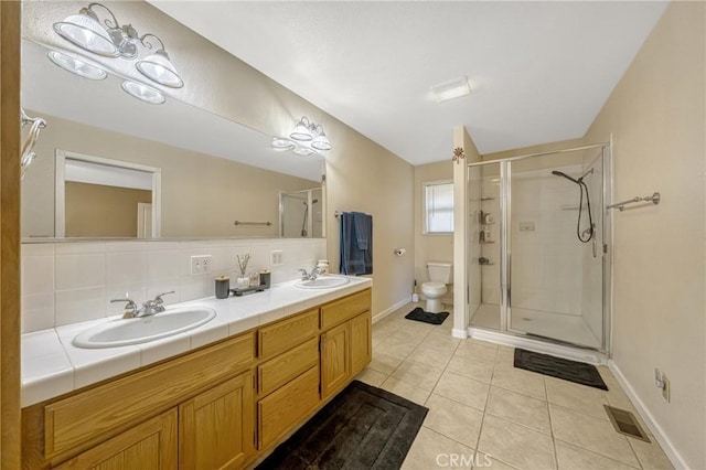 bathroom with backsplash, tile patterned flooring, vanity, walk in shower, and toilet