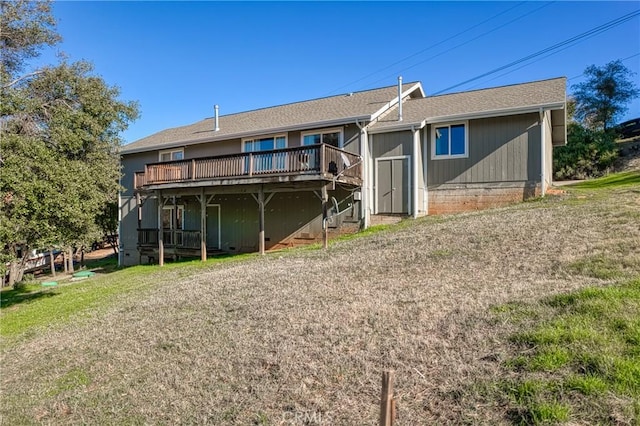 back of property featuring a wooden deck and a yard