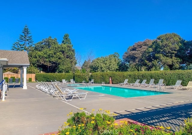 pool with a patio and fence