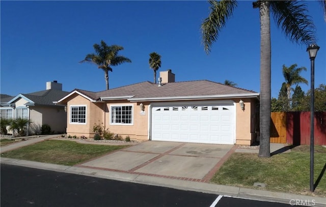 single story home featuring stucco siding, an attached garage, a front lawn, and fence