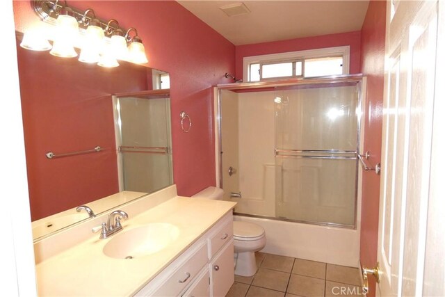 full bathroom with tile patterned floors, combined bath / shower with glass door, toilet, and vanity