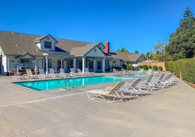 community pool featuring a patio area and fence