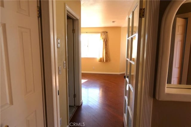 hall with baseboards and dark wood-style flooring