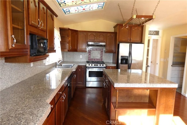 kitchen with a sink, stainless steel appliances, vaulted ceiling, dark wood-type flooring, and under cabinet range hood