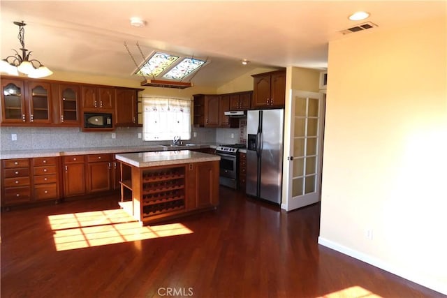 kitchen with visible vents, glass insert cabinets, lofted ceiling, decorative backsplash, and appliances with stainless steel finishes