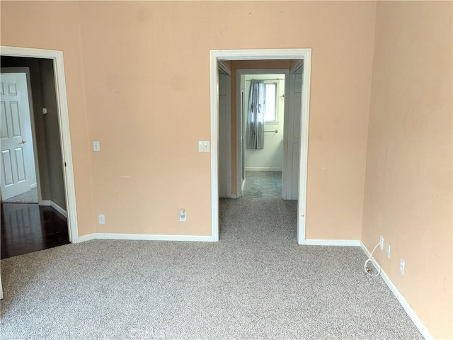 empty room with baseboards and carpet