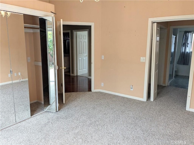 unfurnished bedroom featuring a closet, baseboards, and carpet