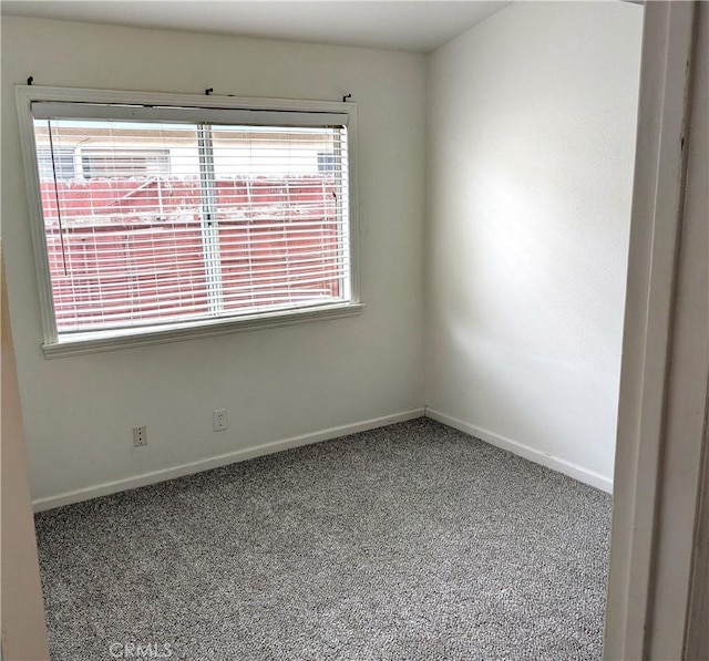 carpeted empty room with baseboards