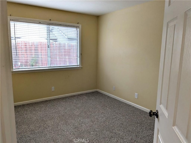 unfurnished room featuring carpet flooring and baseboards