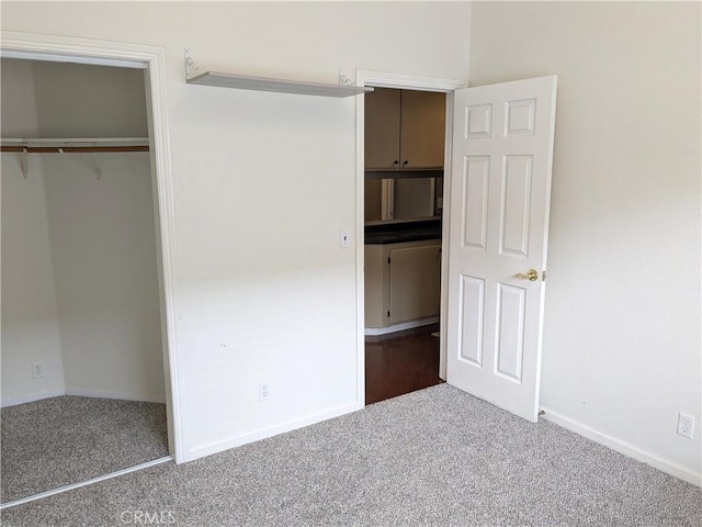 unfurnished bedroom featuring carpet flooring, baseboards, and a closet