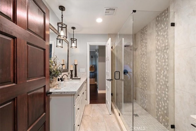 bathroom with vanity and a shower with door