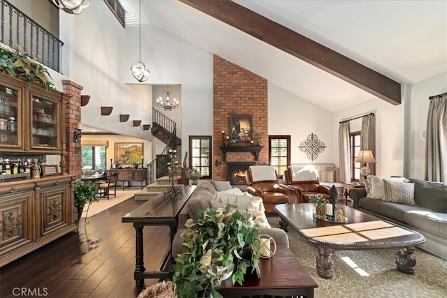 living room featuring high vaulted ceiling, dark hardwood / wood-style flooring, a notable chandelier, a brick fireplace, and beam ceiling