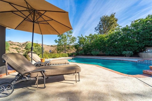 view of pool featuring a mountain view and a patio area