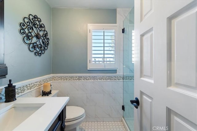 bathroom with tile walls, tile patterned flooring, vanity, walk in shower, and toilet