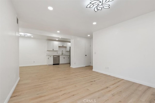 unfurnished living room with light hardwood / wood-style floors and sink