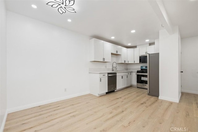 kitchen featuring sink, light wood-type flooring, white cabinets, and appliances with stainless steel finishes