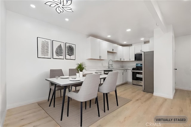 dining space with sink and light hardwood / wood-style floors