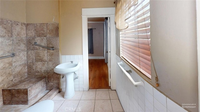 bathroom with toilet, tile patterned flooring, and tile walls