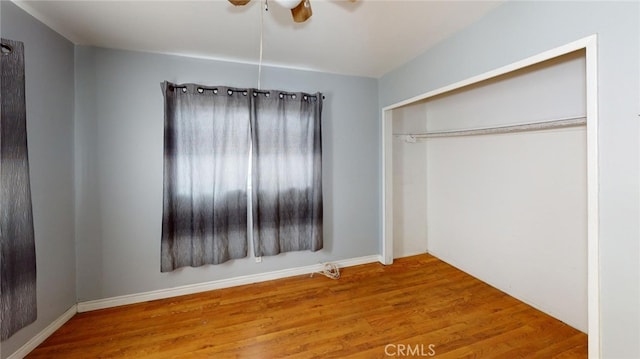 unfurnished bedroom featuring hardwood / wood-style flooring, a closet, and ceiling fan