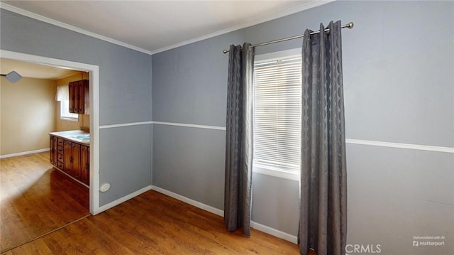 unfurnished dining area featuring hardwood / wood-style flooring, ornamental molding, and a healthy amount of sunlight