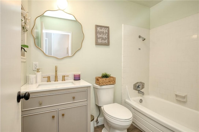 full bathroom featuring vanity, tiled shower / bath combo, and toilet