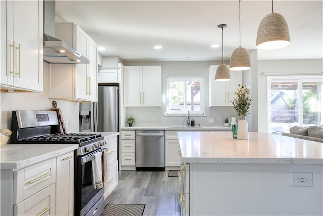 kitchen with appliances with stainless steel finishes, decorative light fixtures, a center island, and white cabinets