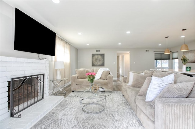 living room with plenty of natural light, a fireplace, and light hardwood / wood-style floors