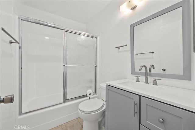 full bathroom featuring toilet, vanity, bath / shower combo with glass door, and tile patterned flooring