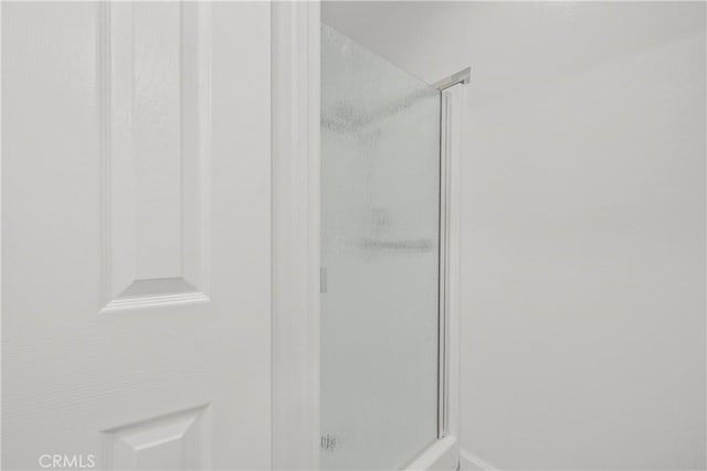 bathroom featuring a shower with door