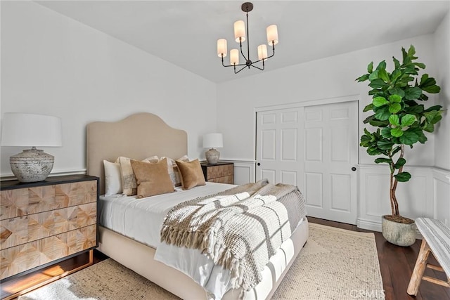 bedroom featuring dark hardwood / wood-style floors, a chandelier, and a closet