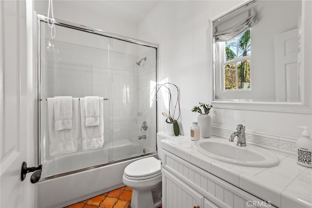 full bathroom with tile patterned flooring, enclosed tub / shower combo, vanity, and toilet