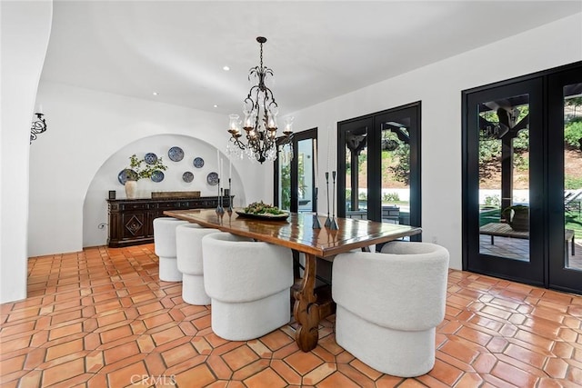 dining area featuring light tile patterned floors, an inviting chandelier, and french doors