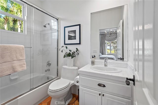 full bathroom with enclosed tub / shower combo, a healthy amount of sunlight, vanity, and toilet