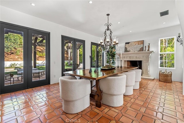 tiled dining room featuring an inviting chandelier and french doors