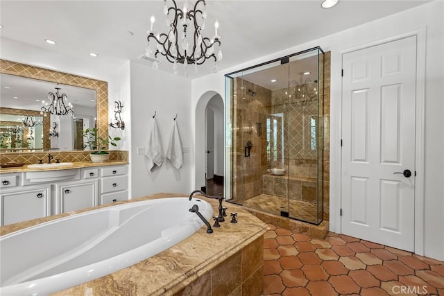 bathroom with vanity, a notable chandelier, tile patterned floors, and plus walk in shower