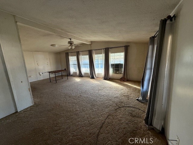 misc room featuring lofted ceiling with beams, ceiling fan, carpet, and a textured ceiling