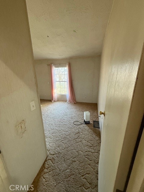 carpeted empty room with a textured ceiling