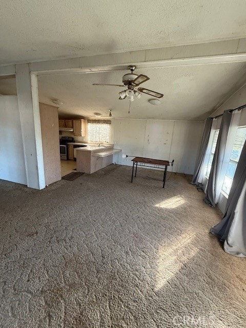 interior space featuring ceiling fan, light colored carpet, and a textured ceiling