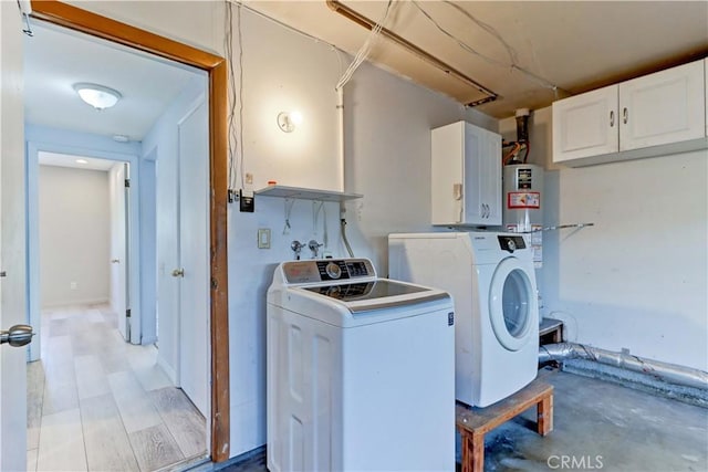 washroom featuring cabinets, independent washer and dryer, and water heater