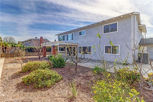 rear view of house featuring central AC unit and a patio