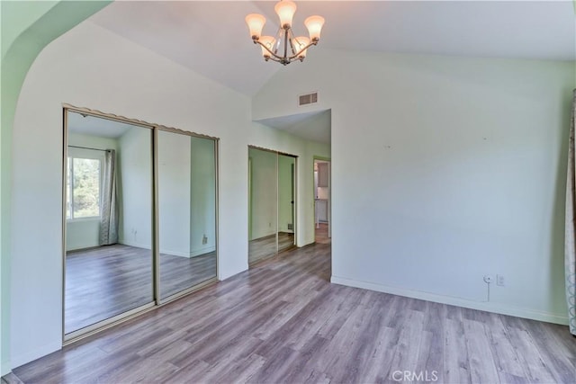 interior space featuring light hardwood / wood-style flooring, vaulted ceiling, and a chandelier