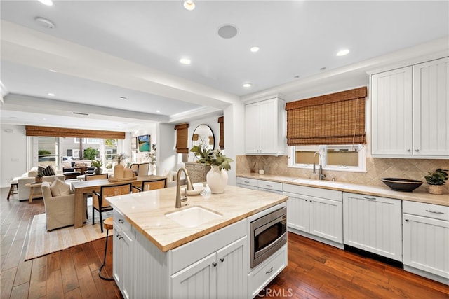 kitchen with white cabinetry, sink, and stainless steel microwave