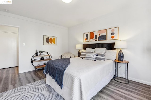 bedroom with hardwood / wood-style flooring and ornamental molding