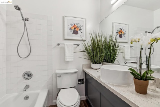 full bathroom with tiled shower / bath, vanity, and toilet